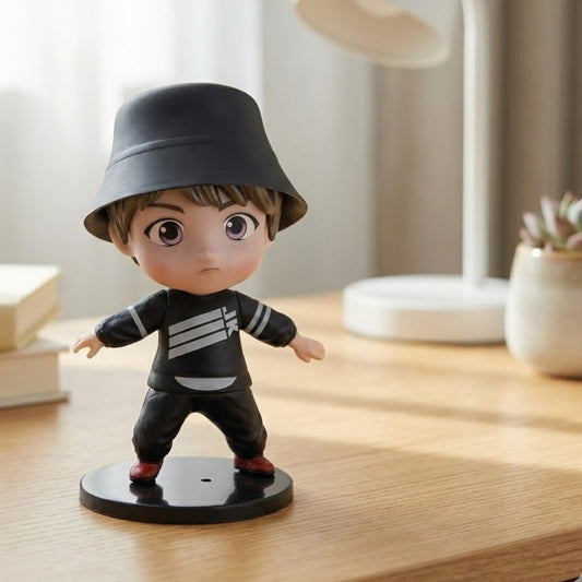 12cm TinyTan Jungkook figure in "Dynamite" outfit, smiling, resting on a computer monitor.